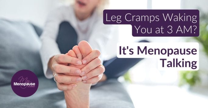 Midlife woman sitting on the edge of her bed holding her calf — menopause leg cramps at night