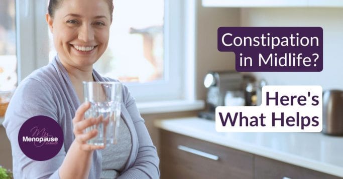 Midlife woman in a bright kitchen with herbal tea and water — gentle constipation relief