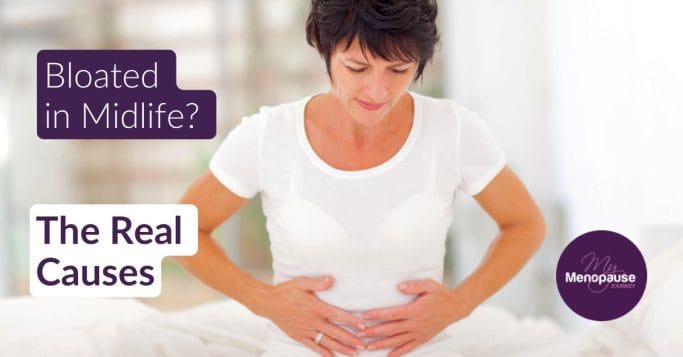 Midlife woman gently holding her belly — menopause bloating in midlife