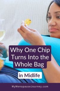 Midlife woman on the couch with chips and a glass of wine — emotional eating in menopause